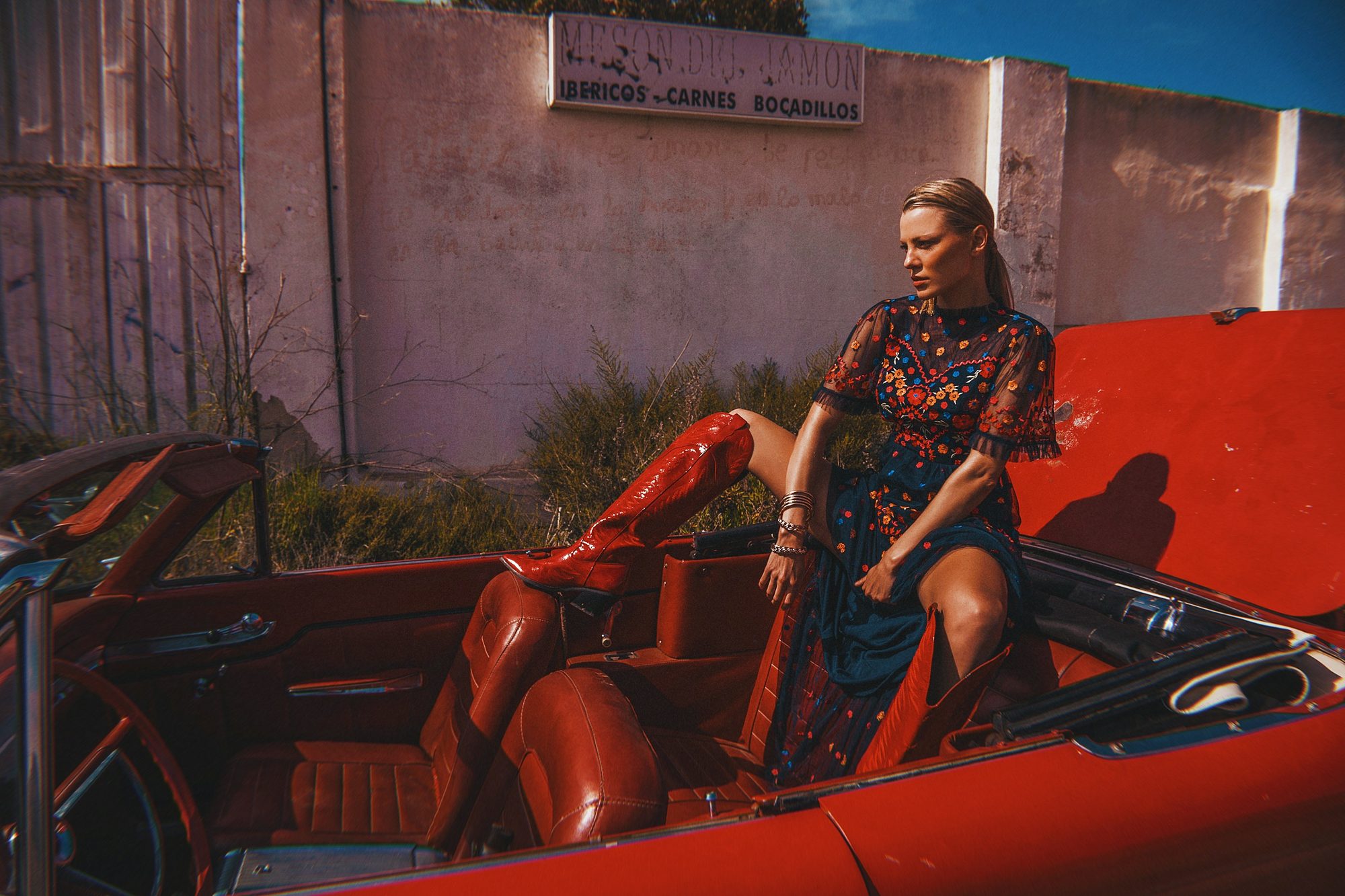 Red Cadillac — Colour, wardrobe, and a convertible against a painted wall.